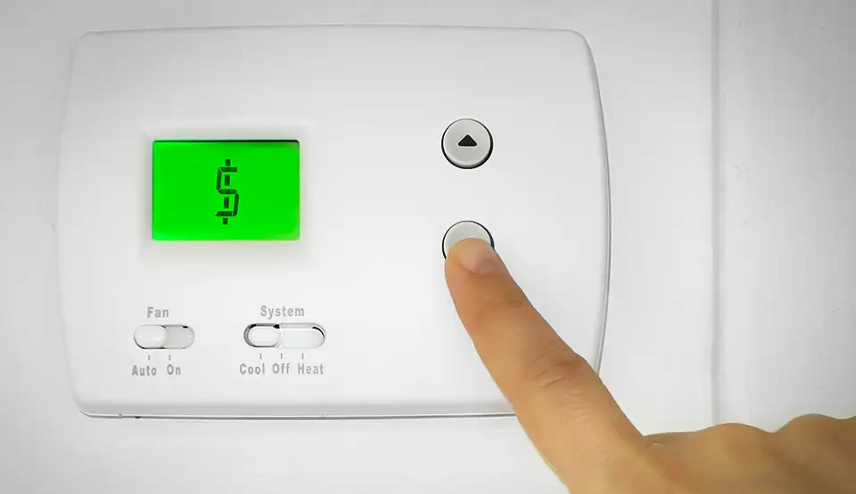 A wall thermostat with a $ in the window, indicating how much money you can save with programmable thermostats