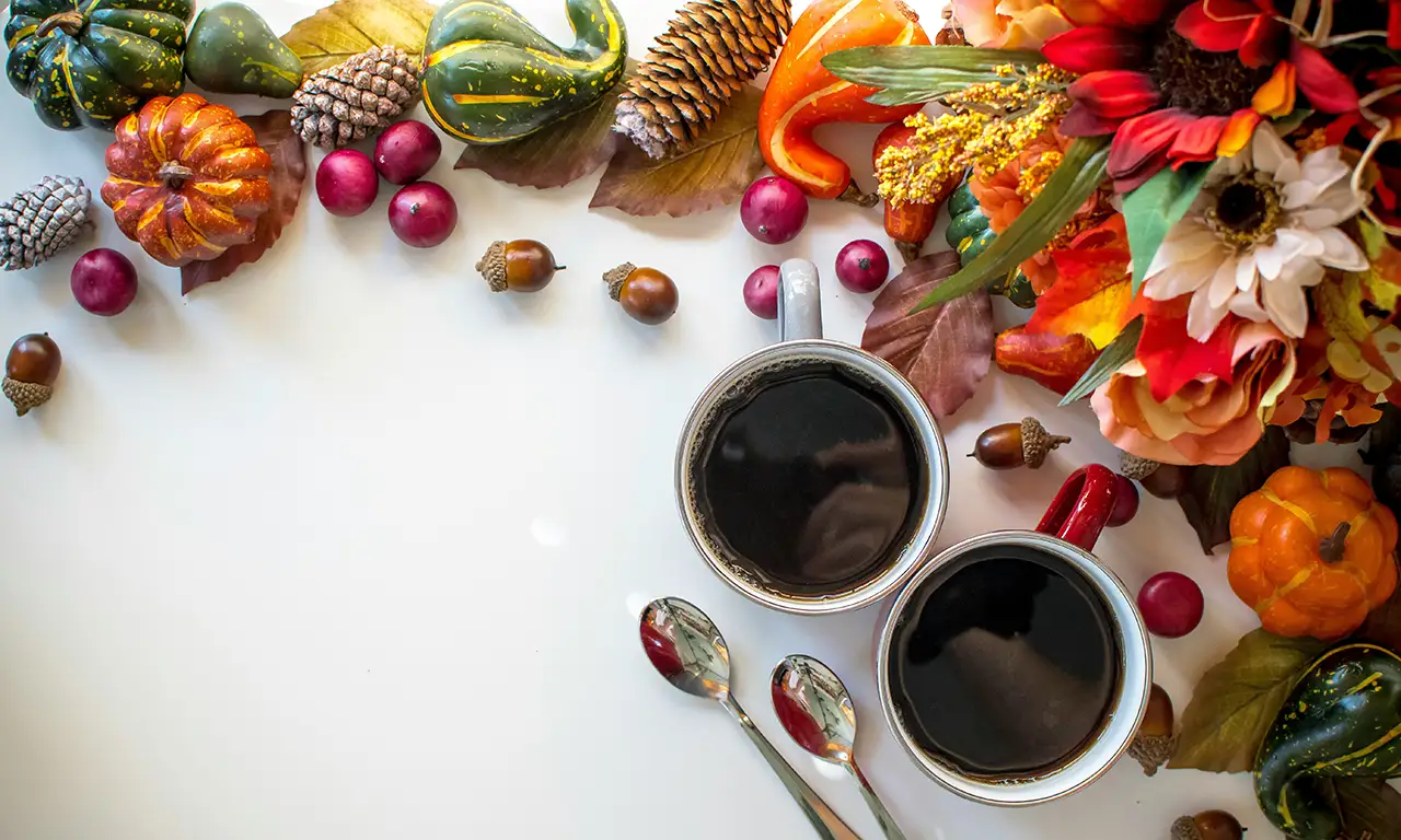 An array of autumn themed decor along with two cups of tea.