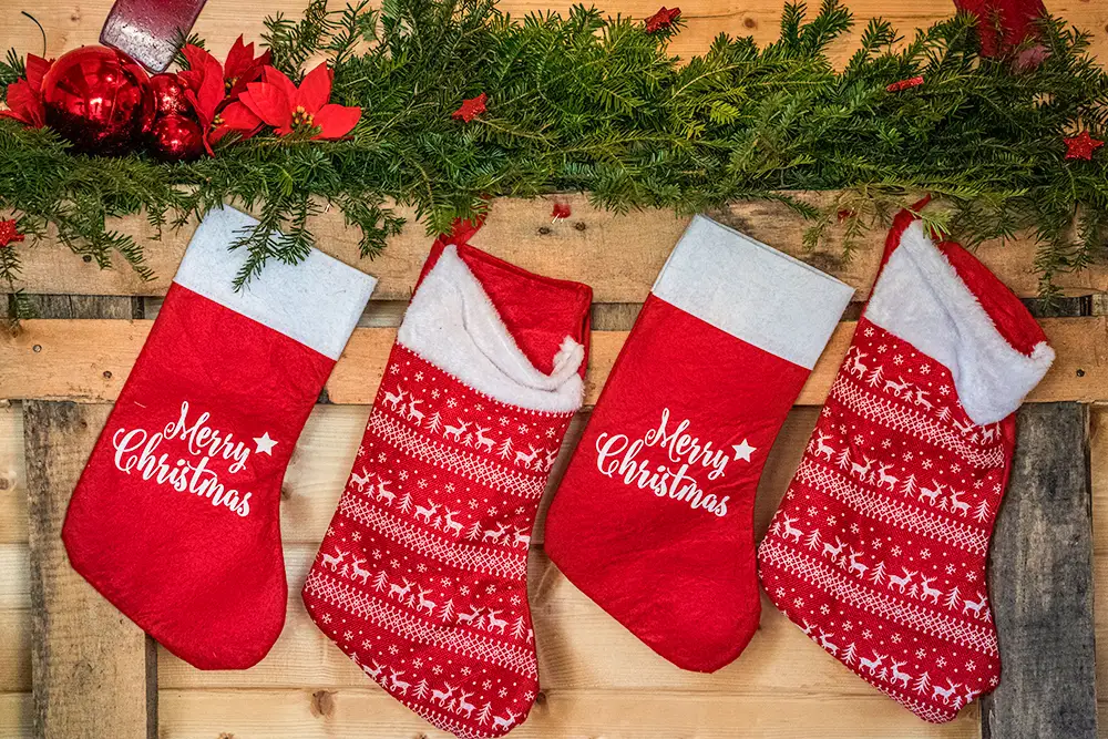 Row of four Christmas stockings hanging from the mantle