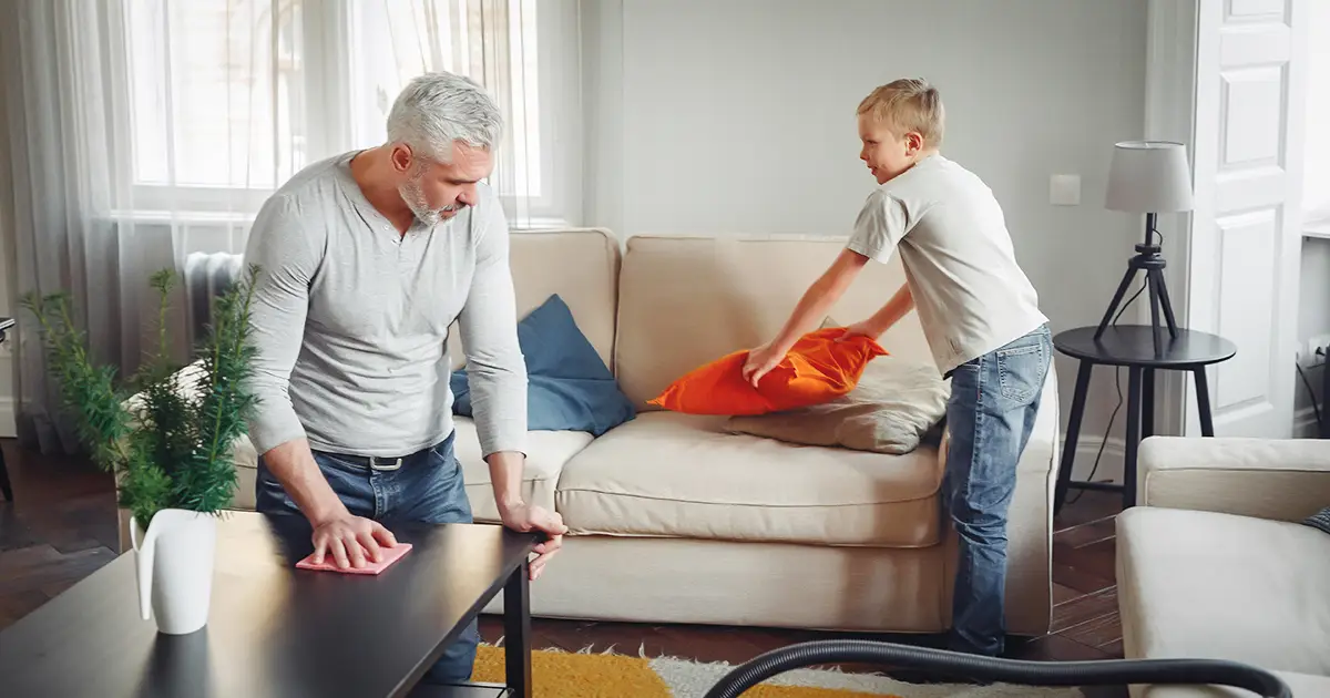 A man and his grandson clean up the living room