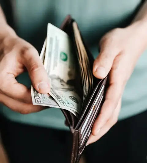 Customer pulling out wallet to pay for expensive AC repairs.